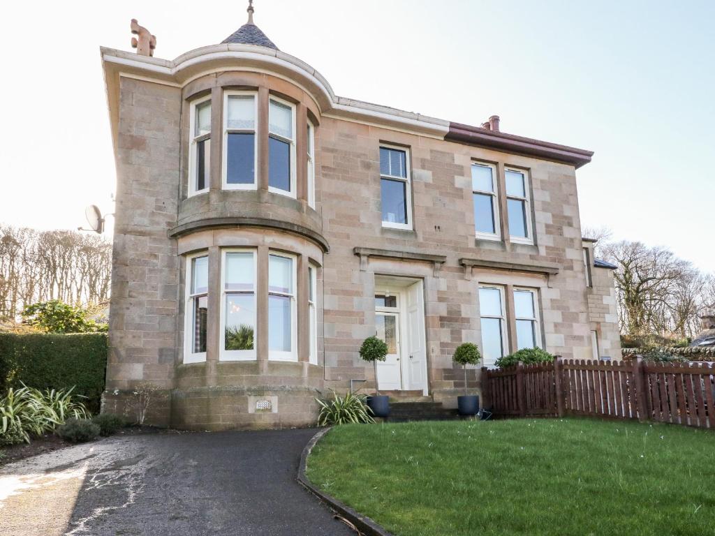 une grande maison en briques avec une clôture devant elle dans l'établissement 1 Craiganrioch, à Campbeltown