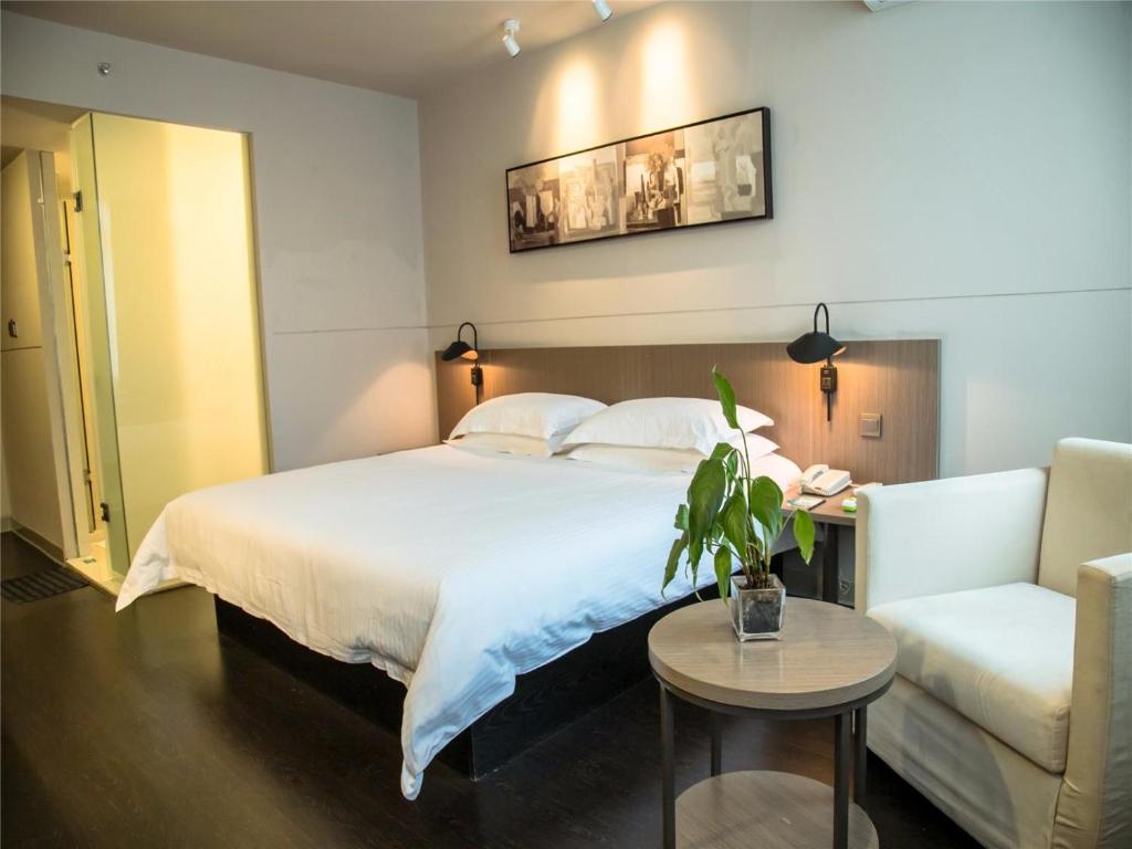 1 dormitorio con cama, mesa y sofá en Jinjiang Inn Select Qiaosinan Metro Station, Hangzhou en Hangzhou