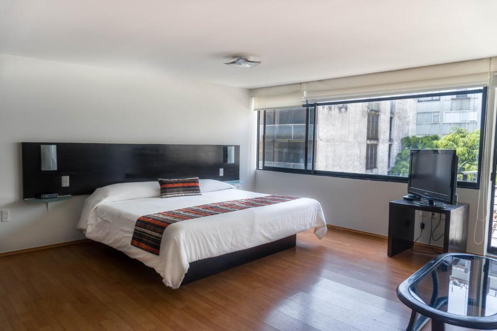 1 dormitorio con 1 cama y TV de pantalla plana en Grupo Kings Suites -Platon 436, en Ciudad de México