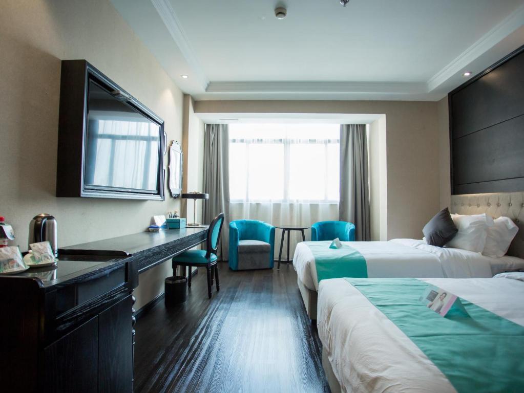 ein Hotelzimmer mit 2 Betten und einem Schreibtisch in der Unterkunft Xana hotel Hangzhou bus north station Wanda in Hangzhou