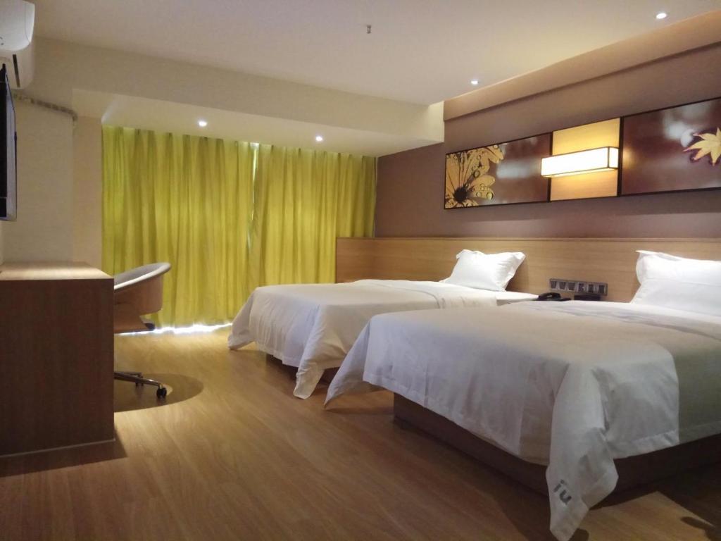 IU Hotel Guiyang Jinyang Century City Shopping Center Chayuan Village Metro Vanke tesisinde bir odada yatak veya yataklar