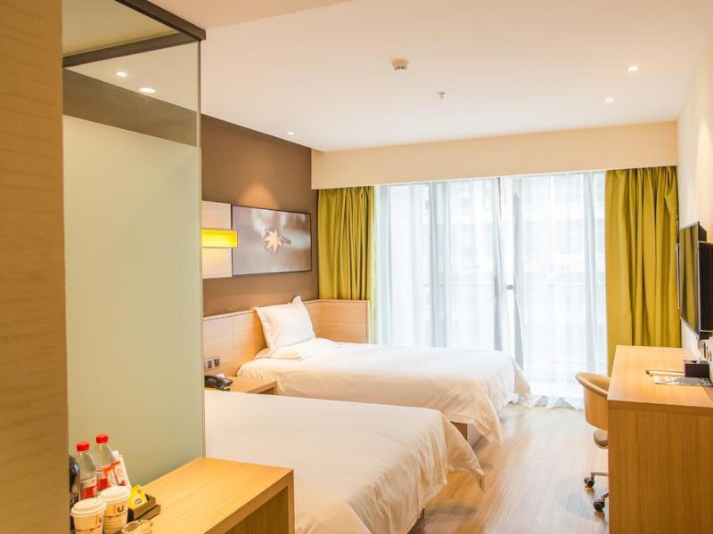 Habitación de hotel con 2 camas y espejo en IU Hotel Guiyang International Convention and Exhibition Center Financial City en Guiyang