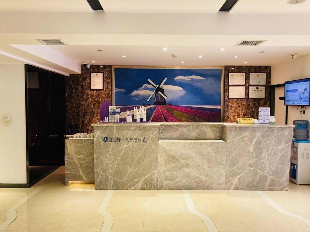 a lobby with a painting of a windmill on the wall at Lavande Hotel Guiyang Flower Orchard Fortune Plaza in Guiyang