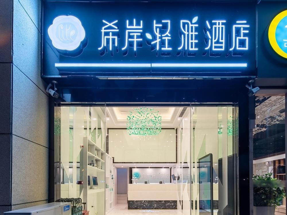 eine Ladefront mit einem blauen Schild über einem Fenster in der Unterkunft Xana Hotel Guiyang International Convention and Exhibition Center Financial City Store in Guiyang
