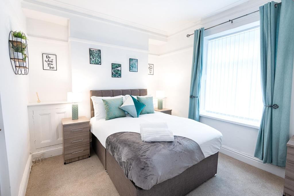 a bedroom with a large bed and a window at Working in Swansea - Try us out in Swansea