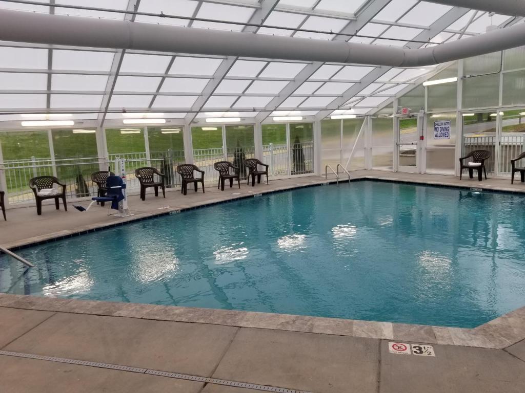 a large swimming pool with tables and chairs in a building at Vacation Lodge in Pigeon Forge