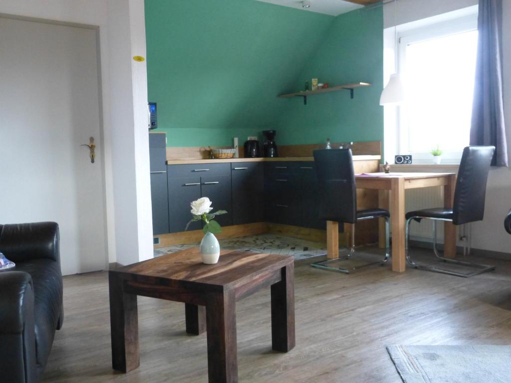 a living room with a table and a kitchen at Ferienwohnung Ochtmissen in Lüneburg