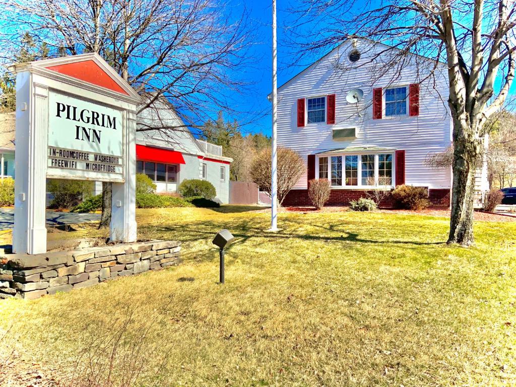 a white house with a pizza inn sign in the yard at Pilgrim Inn in Lee