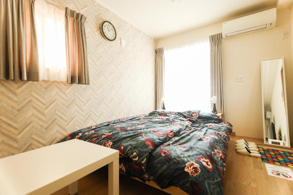 ein Schlafzimmer mit einem Bett und einer Uhr an der Wand in der Unterkunft Chiba LEO Yonju-Yonbankan #MLx in Funabashi