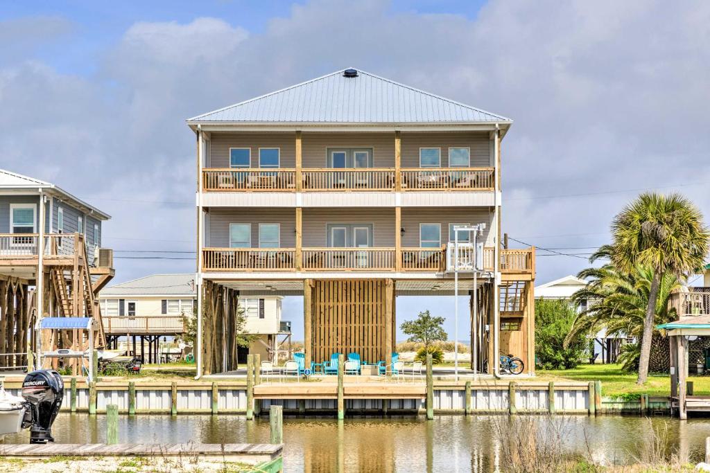 a house on a dock next to a body of water at Luxe Spacious Stilted Home with Kayaks Walk to Beach in Dauphin Island