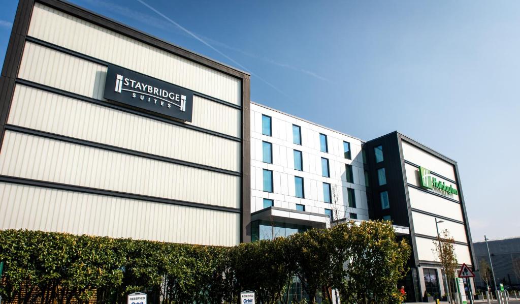 a large building with a clock on the front of it at Staybridge Suites London Heathrow - Bath Road, an IHG Aparthotel in Hillingdon