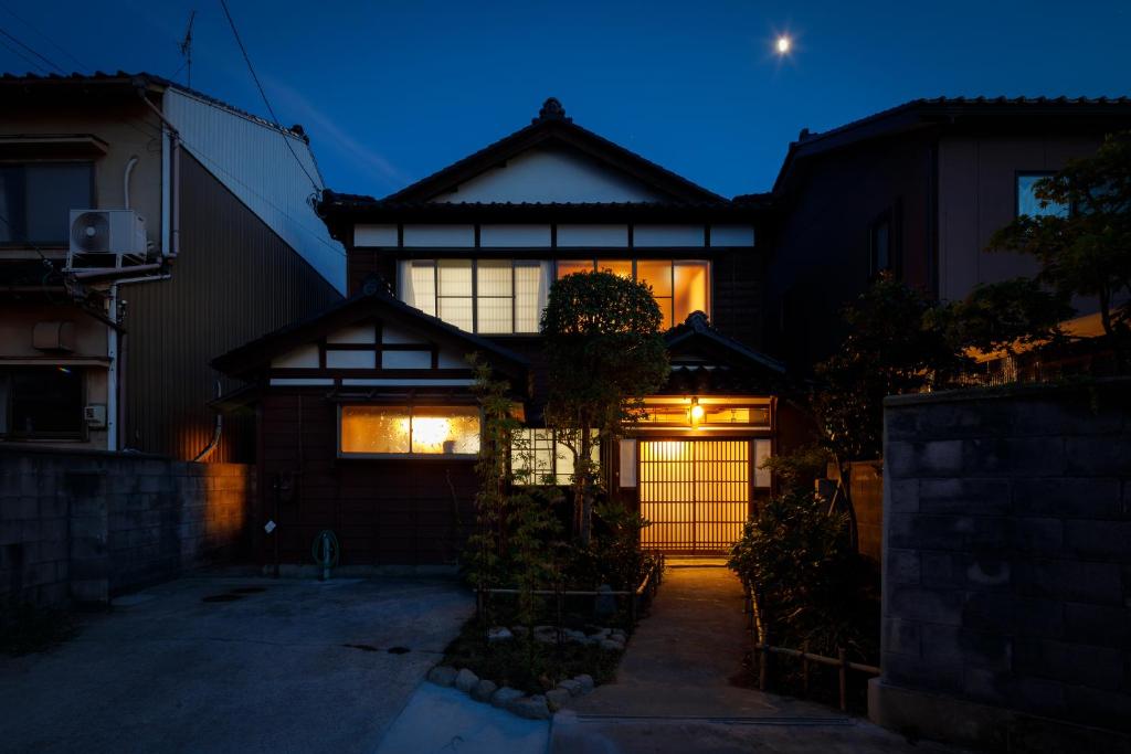 a house with a gate in front of it at night at Tsunagian TABI-NE in Kanazawa