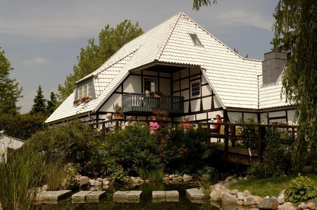 une maison avec un toit en gambrel et un jardin dans l'établissement Hotel Weisser Hof, à Malente