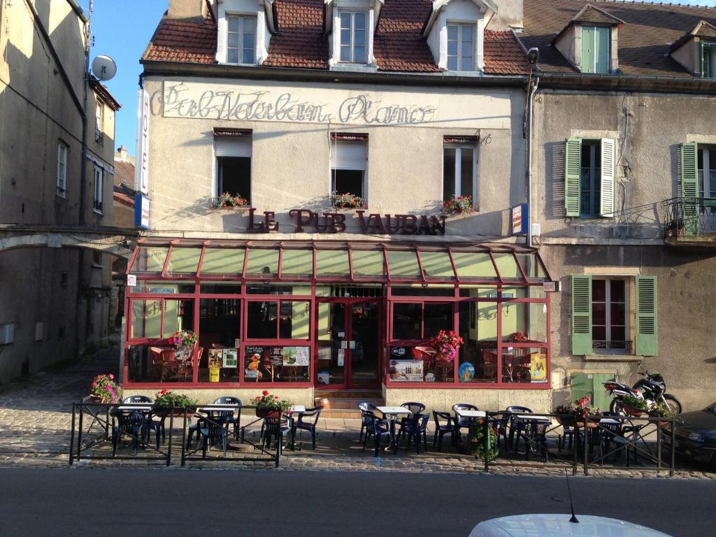 un restaurante con mesas y sillas frente a un edificio en Pub Vauban en Avallon