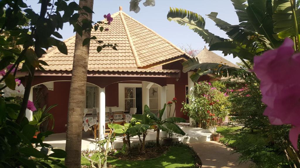 a house with a garden and flowers at Villa Teranga in Saly Portudal