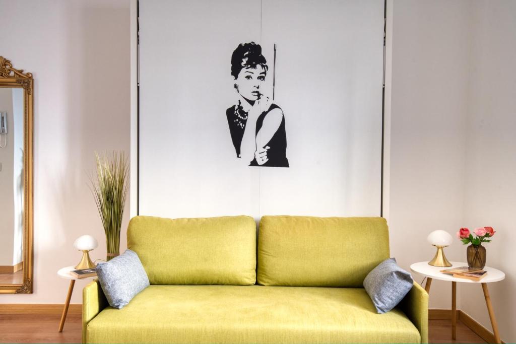 un divano in soggiorno con la foto di un uomo di CaseOspitali - CASA DIVA monolocale in centro storico a Cernusco sul Naviglio
