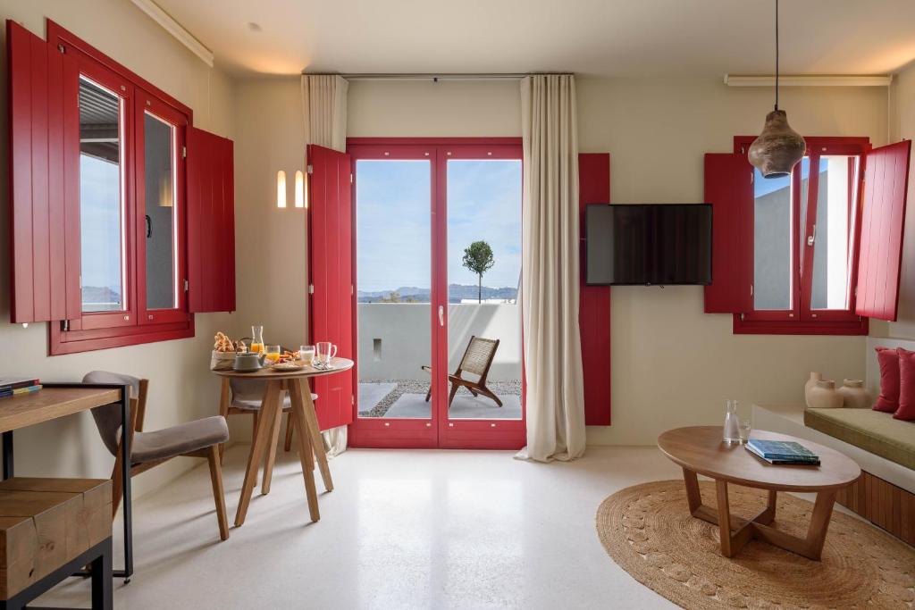 a living room with red cabinets and a red door at Potnia Theron Suites in Akrotiri