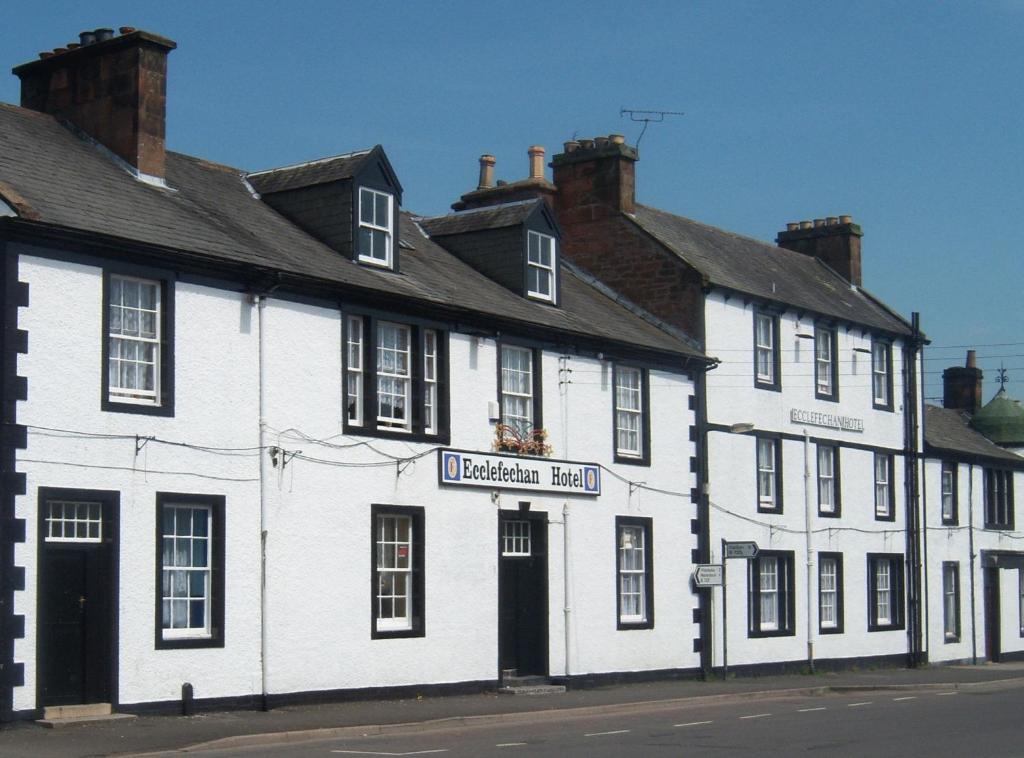 a white building on the side of a street at Ecclefechan Hotel in Ecclefechan