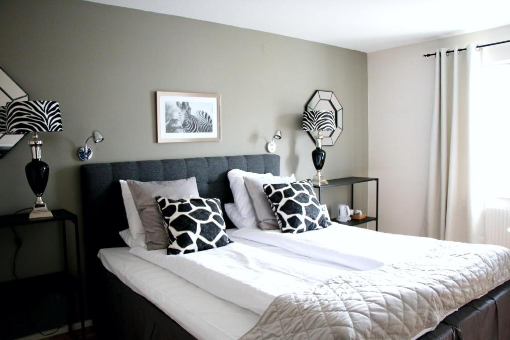 a bedroom with a large bed with black and white pillows at Hotel Carlshamn in Karlshamn