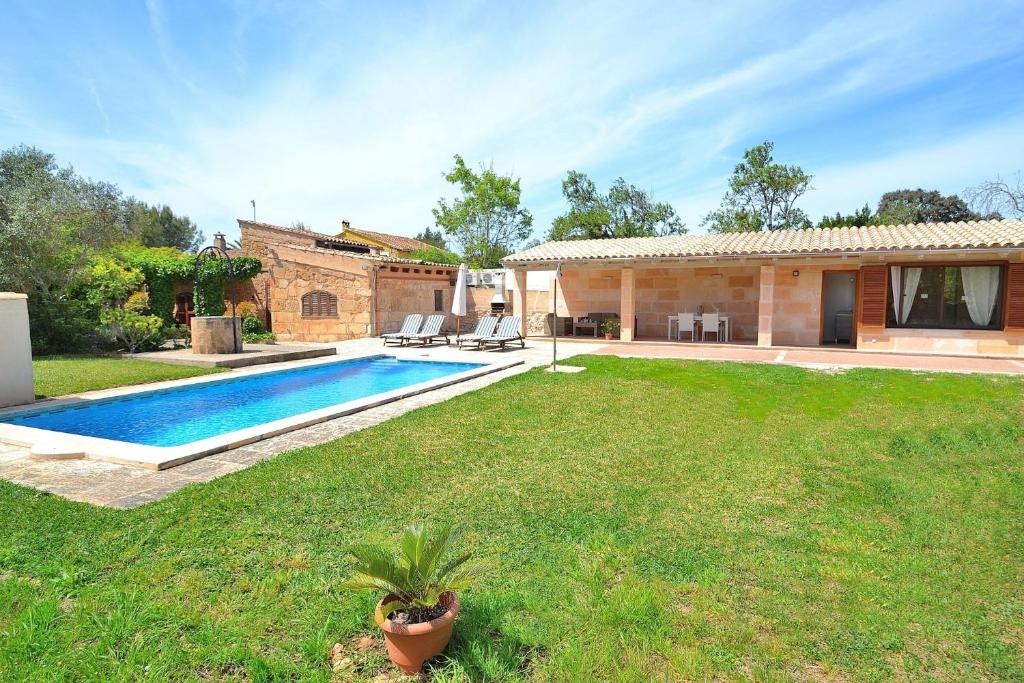 a backyard with a swimming pool and a house at Finca Els Olivers 138 by Mallorca Charme in Alcudia
