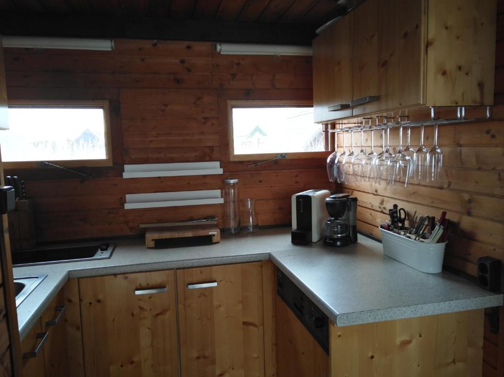cocina con armarios de madera y encimera con gafas en Pfahlbau Rust/Neusiedlersee Sunset II, en Rust