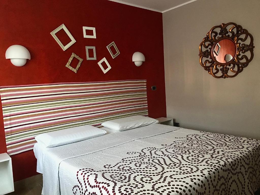 ein Schlafzimmer mit einem weißen Bett und einer roten Wand in der Unterkunft La casetta di Simone in Cassino