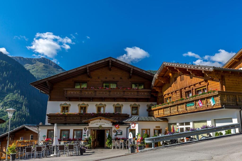 a building in the mountains with mountains in the background at Alpengasthof Pichler in Sankt Veit in Defereggen