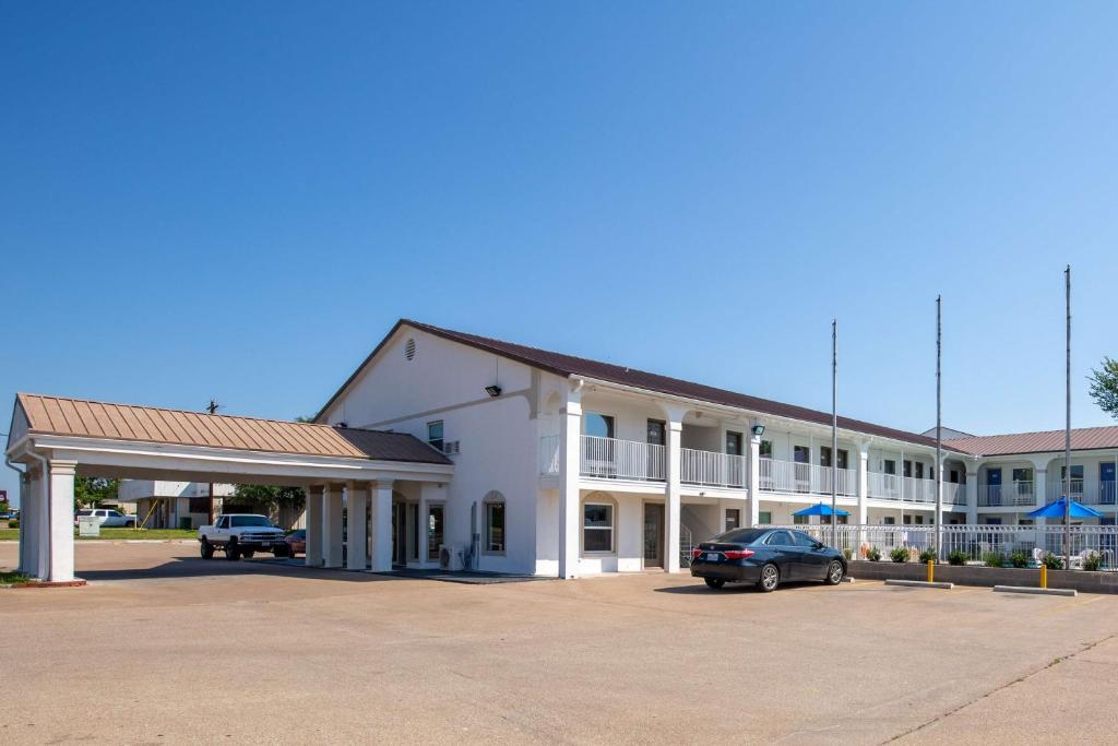 un grande edificio bianco con auto parcheggiate in un parcheggio di Studio 6-Bryan, TX - University Area a Bryan