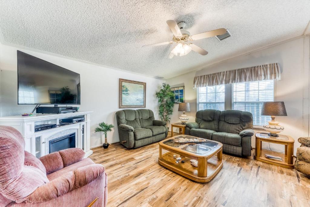 a living room with two couches and a tv at Laguna Hideaway in Panama City Beach
