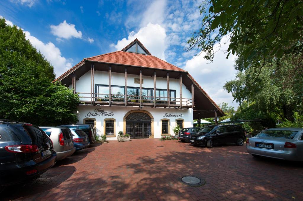 ein Gebäude mit Autos auf einem Parkplatz in der Unterkunft Haus Große Kettler in Bad Laer