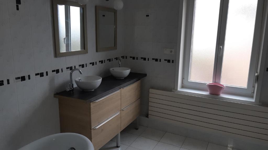a bathroom with two sinks and two mirrors at Les Hauts de Proisy in Proisy
