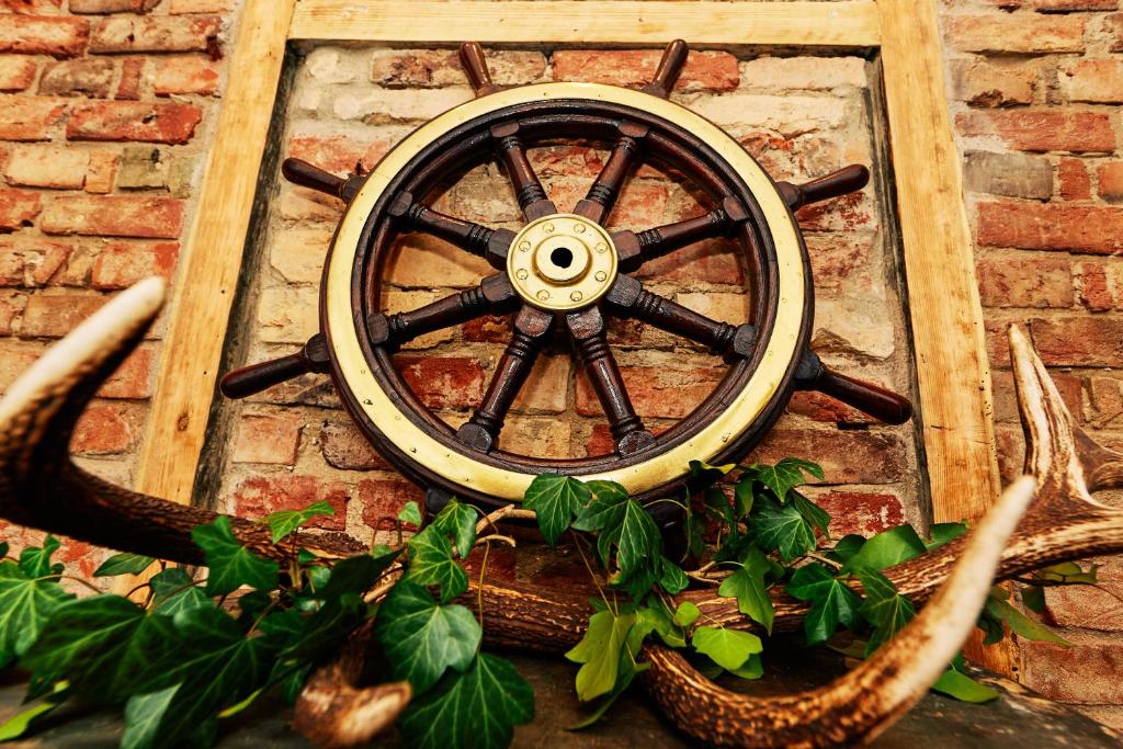 a wooden wheel attached to a brick wall with antlers at Zvejnieka ligzda in Ventspils