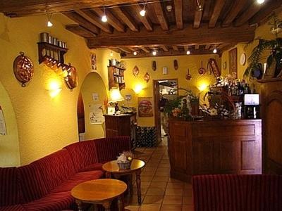 a restaurant with red couches and tables and a bar at Hotel de Bourgogne in Saulieu