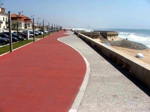 a red sidewalk next to the ocean with cars parked at Villa Granja Sol in São Félix da Marinha
