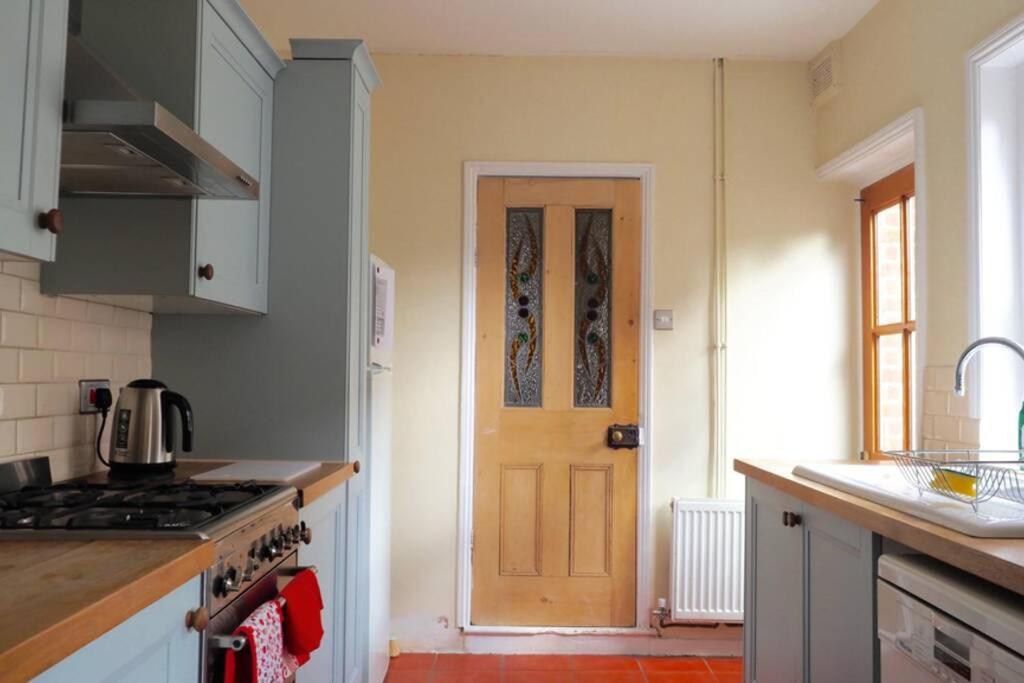 a kitchen with a stove and a door in it at Self contained stylish city home in Norwich