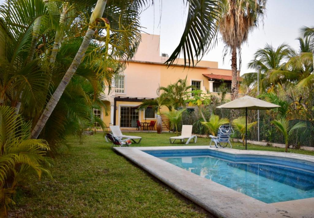 a pool in front of a house with palm trees at Cancun-Soho in Cancún