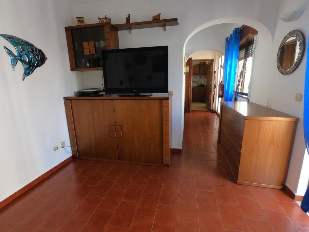a living room with a flat screen tv on a cabinet at Apartamento Vargas in Monte Gordo