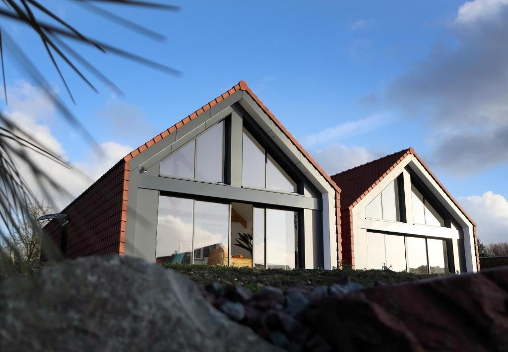 een huis met grote ramen aan de zijkant bij La Cooconing in Fresnicourt-le-Dolmen