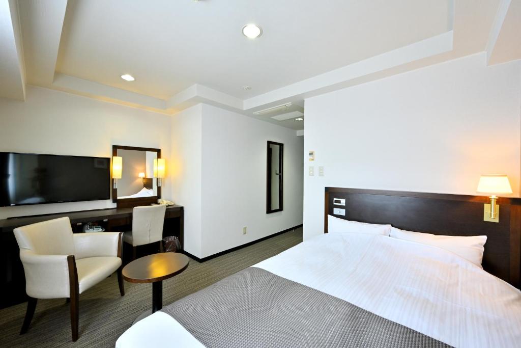 Postel nebo postele na pokoji v ubytování Saijo Urban Hotel