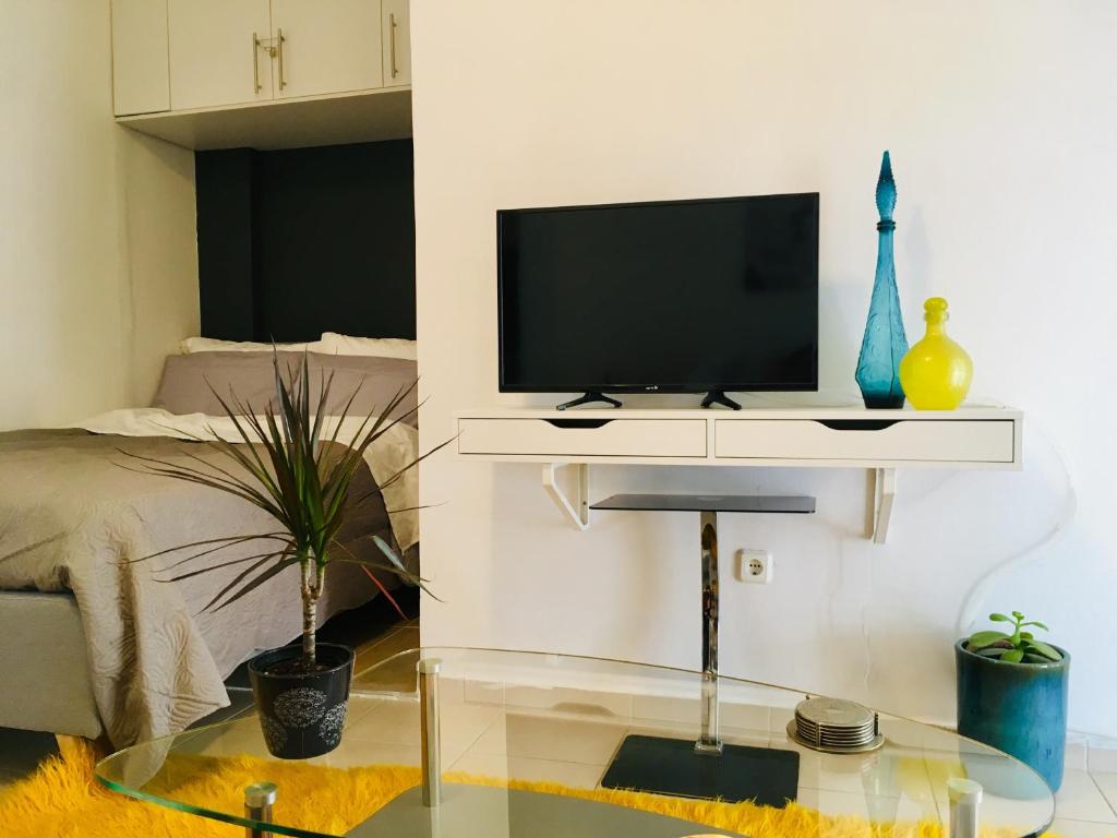 a living room with a tv sitting on a table at Cozy Studio by seaside and tram in Athens