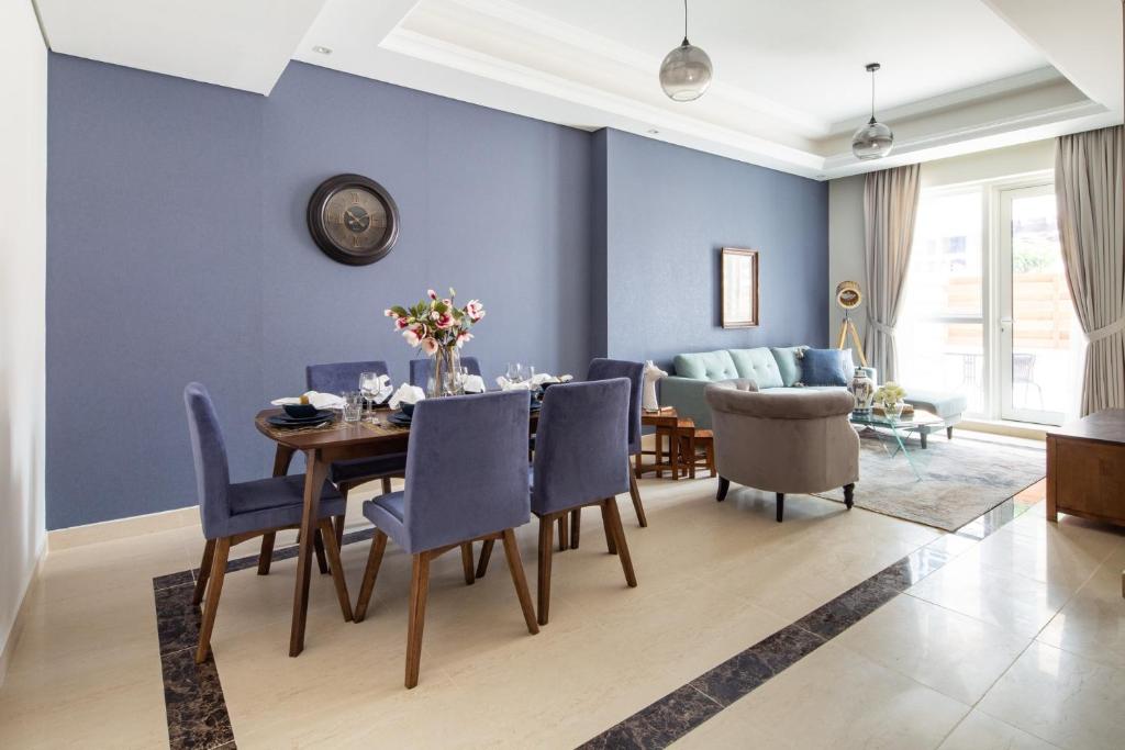 a dining room with blue walls and a table and chairs at Frank Porter - Mon Reve in Dubai