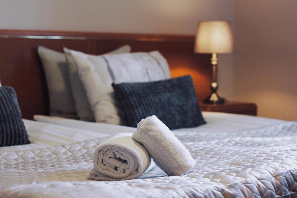 a pair of towels on a bed in a hotel room at Högbo Hotell Skommarsgården in Sandviken