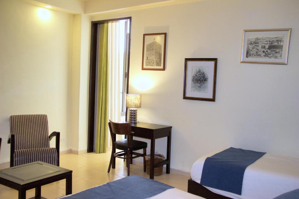 Postel nebo postele na pokoji v ubytování National Hotel - Jerusalem