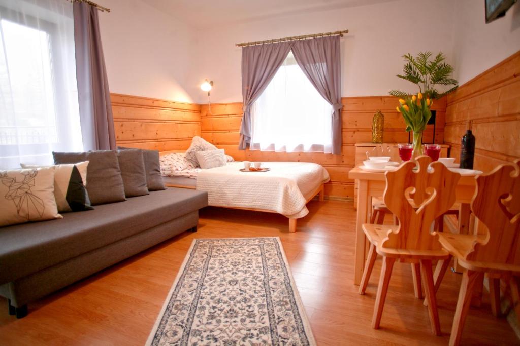 salon z kanapą, łóżkiem i stołem w obiekcie Willa Przy Skoczni w Zakopanem