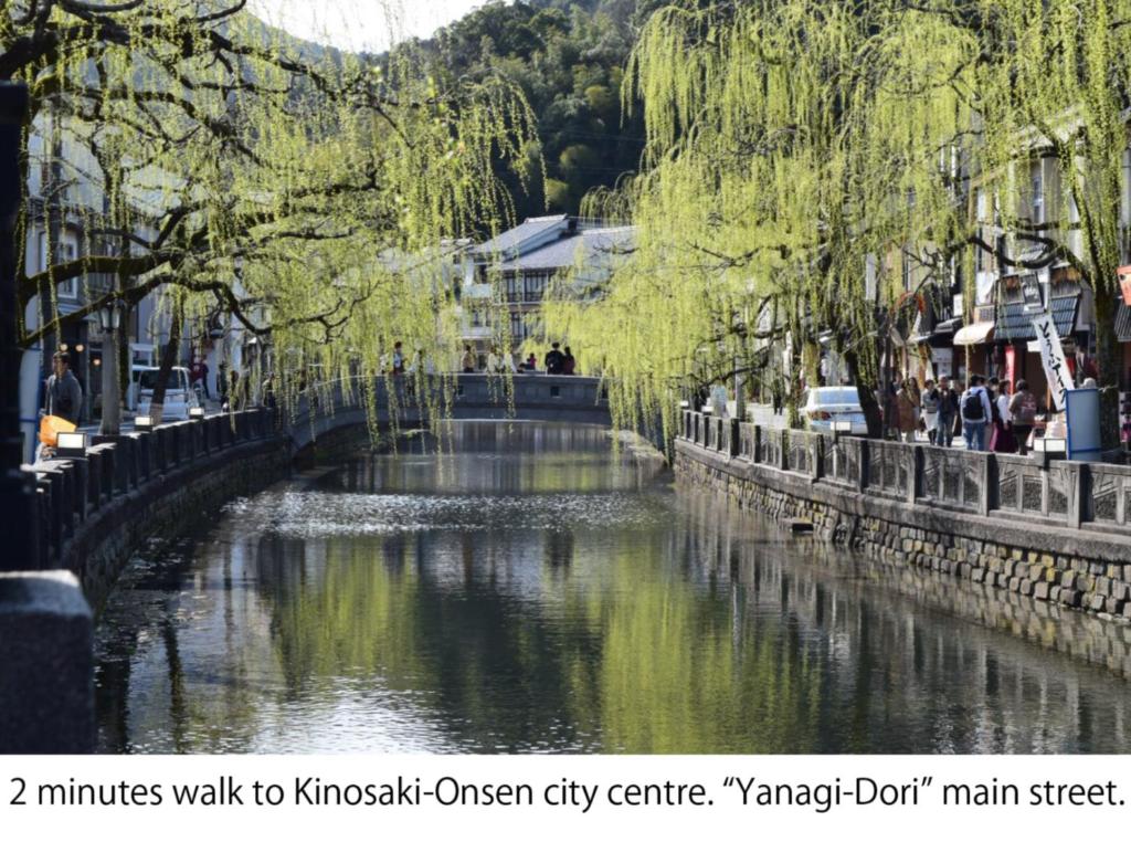 Ein Fluss in einer Stadt mit Leuten, die darauf laufen. in der Unterkunft KINOSAKI KNOT in Toyooka