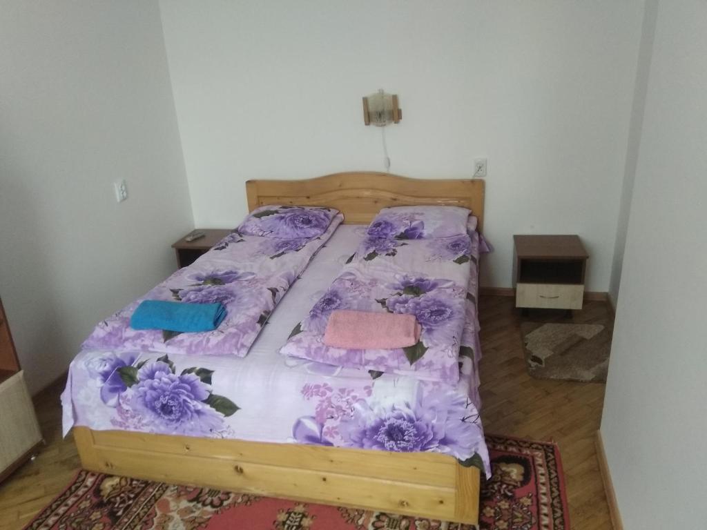 een slaapkamer met een bed met paarse lakens en bloemen bij Двохповерховий будинок з двома апартаментами in Truskavets