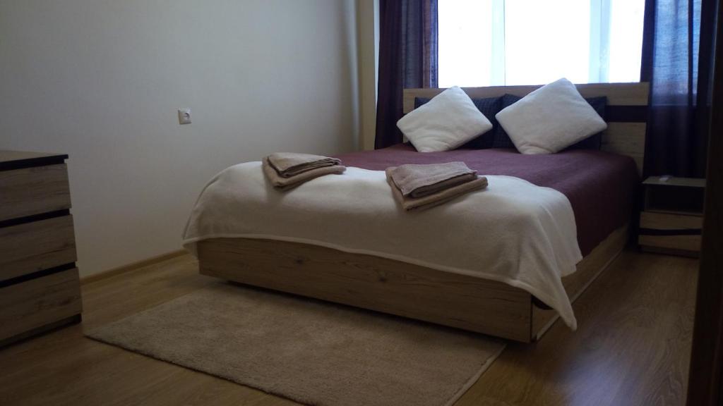 a bedroom with a bed with two towels on it at Bright apartment on top in Panevėžys