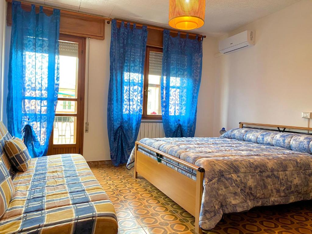 1 Schlafzimmer mit 2 Betten und blauen Vorhängen in der Unterkunft La Riviera in Loreo