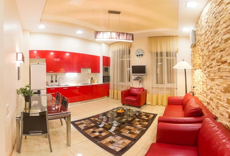 uma sala de estar com mobiliário vermelho e uma cozinha em Alex Apartments near Independence Square - Kiev em Kiev