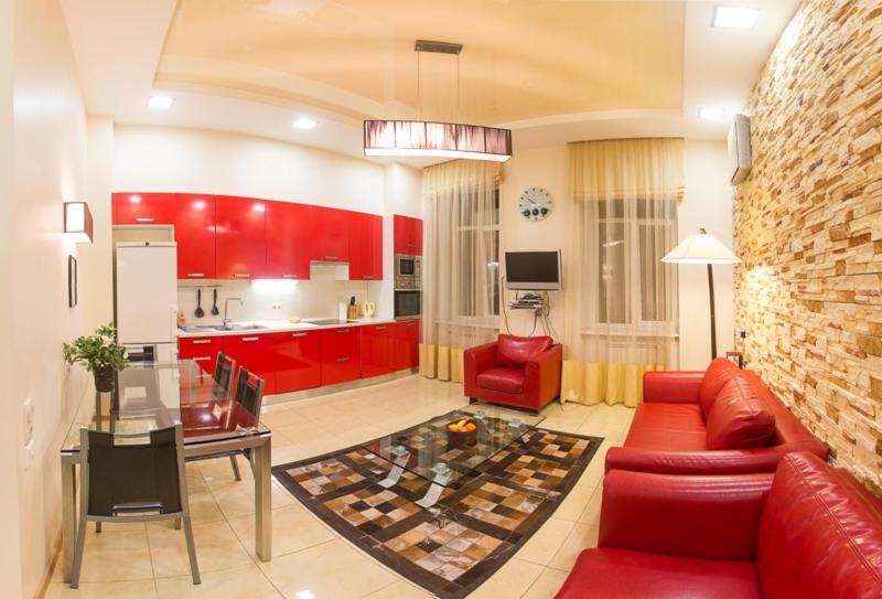 a living room with red furniture and a kitchen at Alex Apartments near Independence Square - Kiev in Kyiv